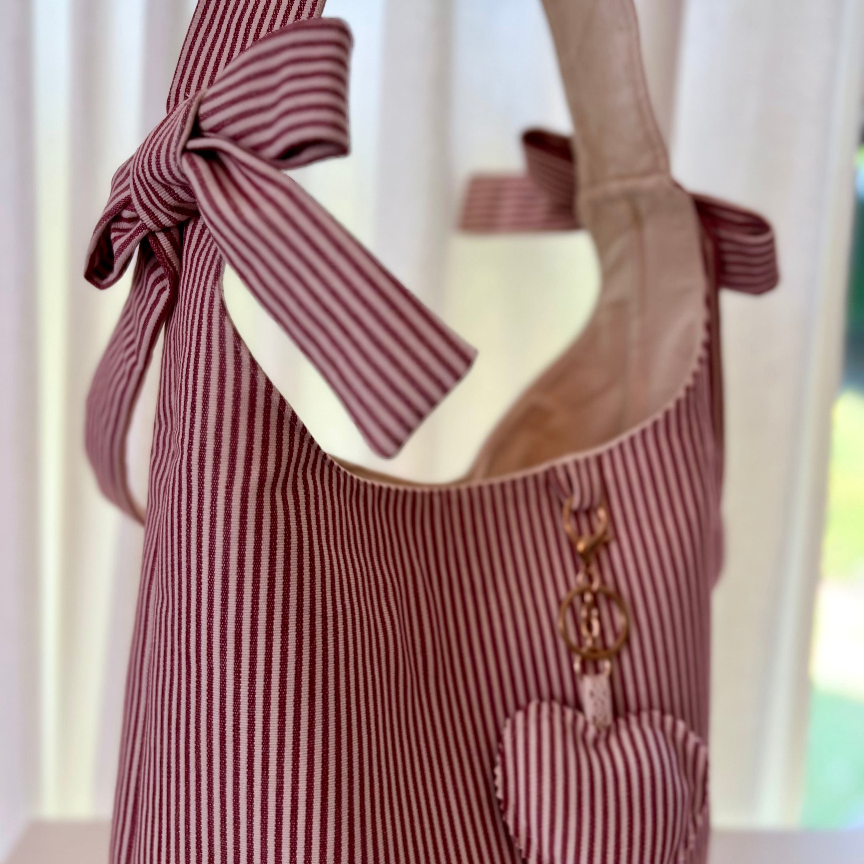 Striped tote bag with a bow and heart detail on a white background