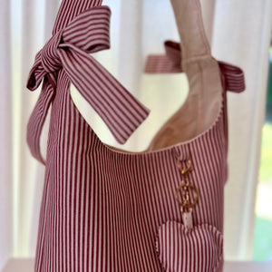 Striped tote bag with a bow and heart detail on a white background