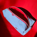 Load image into Gallery viewer, Blue checkered bag with red interior on a red background
