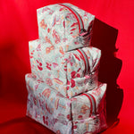 Load image into Gallery viewer, Stack of patterned bags on a red background
