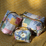 Load image into Gallery viewer, Three patchwork-style bags on a yellow floral background
