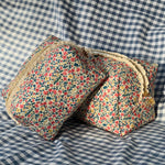 Load image into Gallery viewer, Floral-patterned wedge pillow on a checkered fabric background
