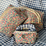 Load image into Gallery viewer, Floral-patterned makeup bags on a checkered fabric background
