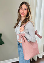 Load image into Gallery viewer, Woman holding a pink striped tote bag indoors
