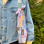 Load image into Gallery viewer, Person wearing a denim jacket with a patchwork quilt draped over their shoulder, standing outdoors.
