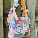 Load image into Gallery viewer, Colorful patchwork tote bag hanging on a wooden fence
